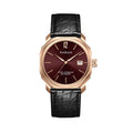 A rose gold watch with a burgundy dial and a leather strap, showing time and date.