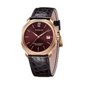 A rose gold watch with a burgundy dial and a leather strap, showing time and date.
