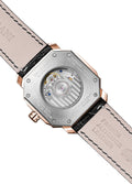 A gold-colored ultra-thin automatic date watch with a brown leather band and a white dial, displayed against a plain background.