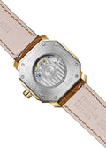 A gold-colored ultra-thin automatic date watch with a brown leather band and a white dial, displayed against a plain background.