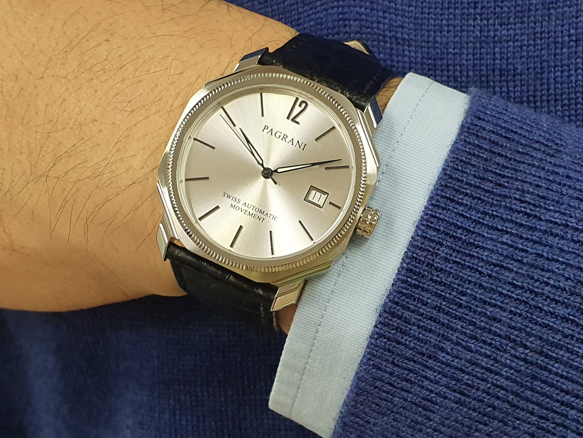 A silver-colored Pagran automatic date watch with a black leather band and a digital date display.