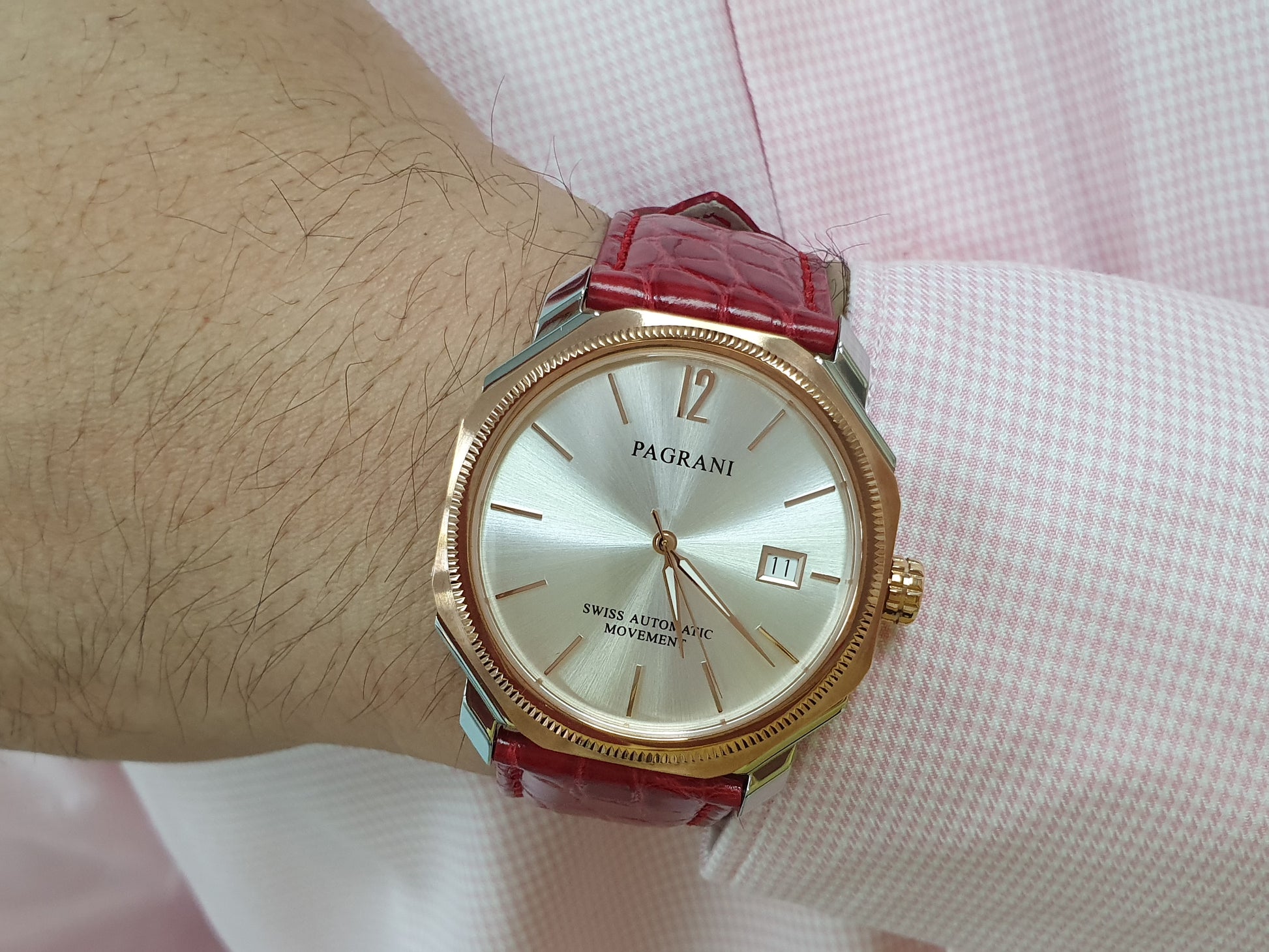 A Pagani brand watch with a red leather band and a silver-colored case featuring a date display.