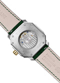 A sleek ultra-thin Swiss automatic date watch with a silver dial, gold bezel, and green leather strap, showing hours, minutes, seconds, and date.